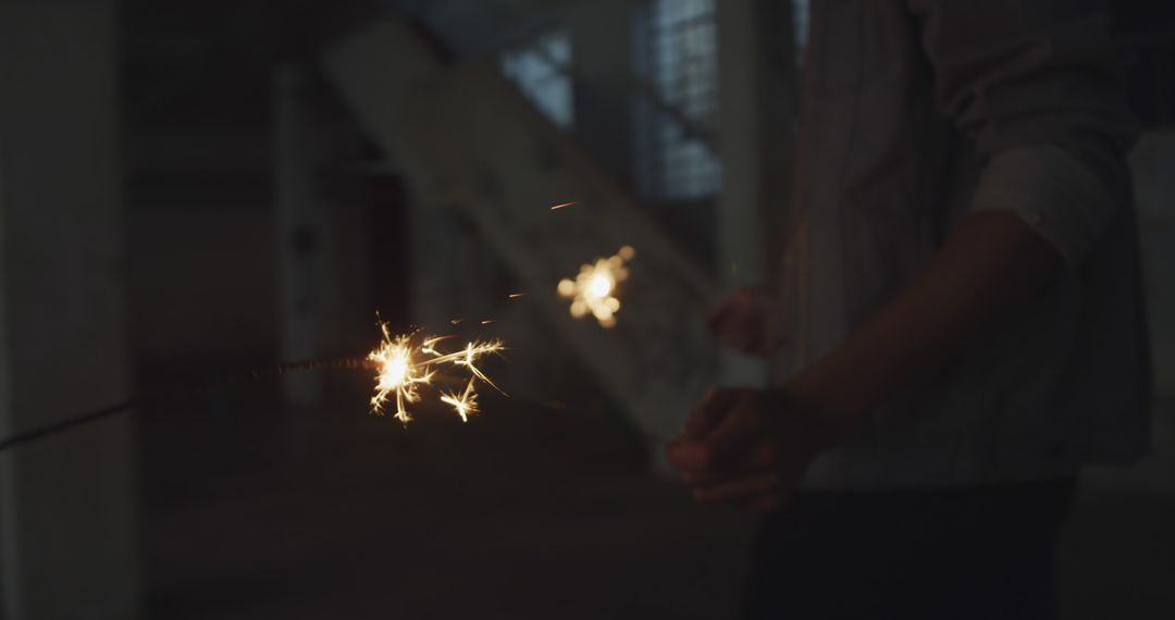 Person Holding Sparklers Indoors Celebrating Festive Occasion - Free Images, Stock Photos and Pictures on Pikwizard.com