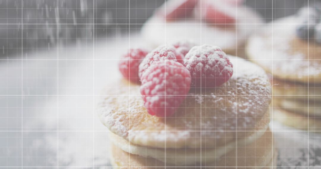 Stacked pancakes topped with raspberries and powdered sugar on doily, airy breakfast closeup