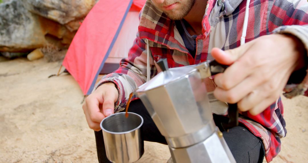 Man Pouring Fresh Coffee at Campground with Red Tent in Background - Free Images, Stock Photos and Pictures on Pikwizard.com