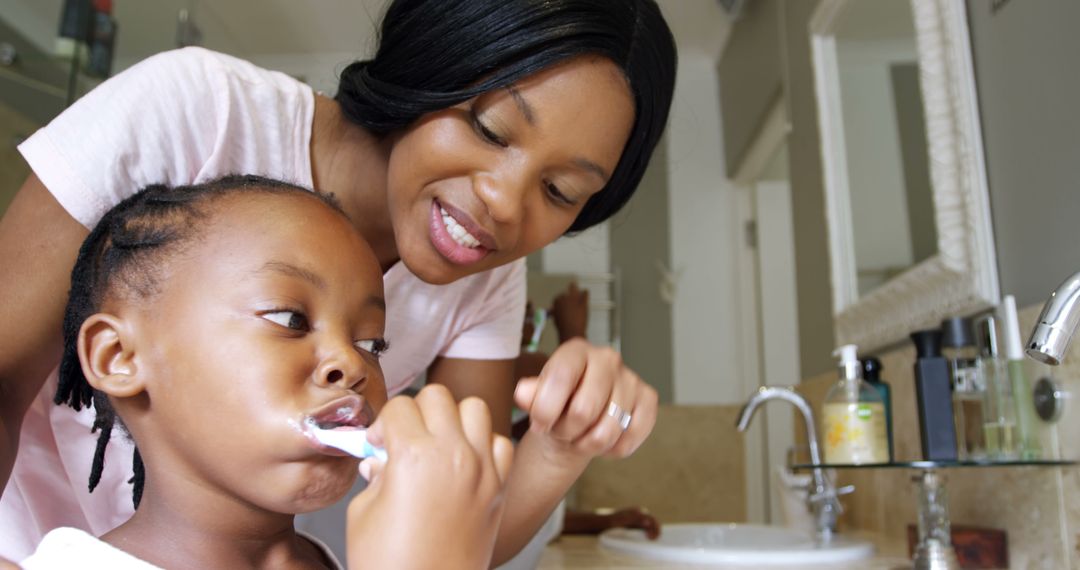 Mother Helping Daughter Brush Teeth in Morning Bathroom Routine - Free Images, Stock Photos and Pictures on Pikwizard.com