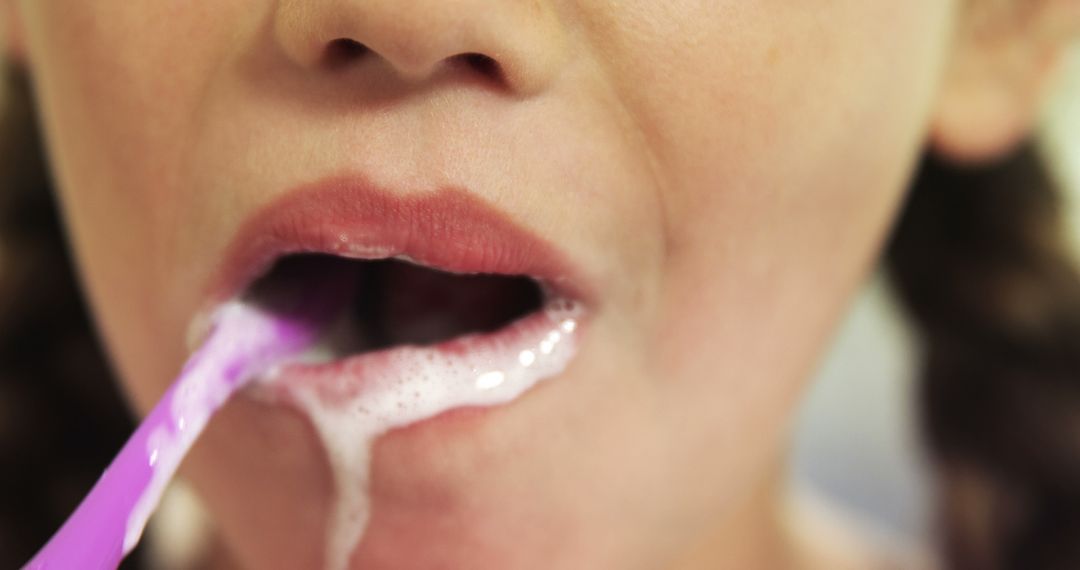 Close-Up of Child Brushing Teeth with Purple Toothbrush - Free Images, Stock Photos and Pictures on Pikwizard.com