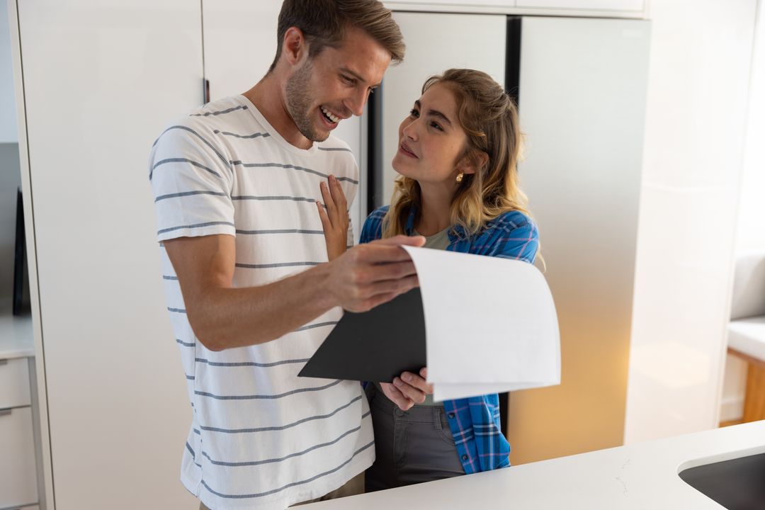 Modern Couple Collaborating on Home Documents in Kitchen