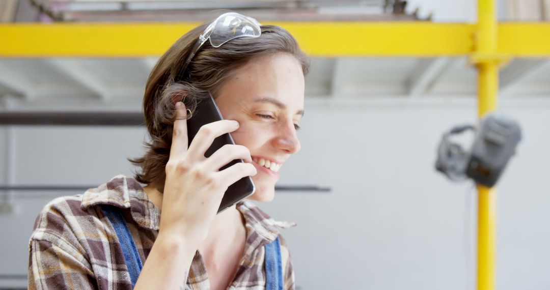 Young Woman Talking on Phone at Construction Site with Confident Smile - Free Images, Stock Photos and Pictures on Pikwizard.com