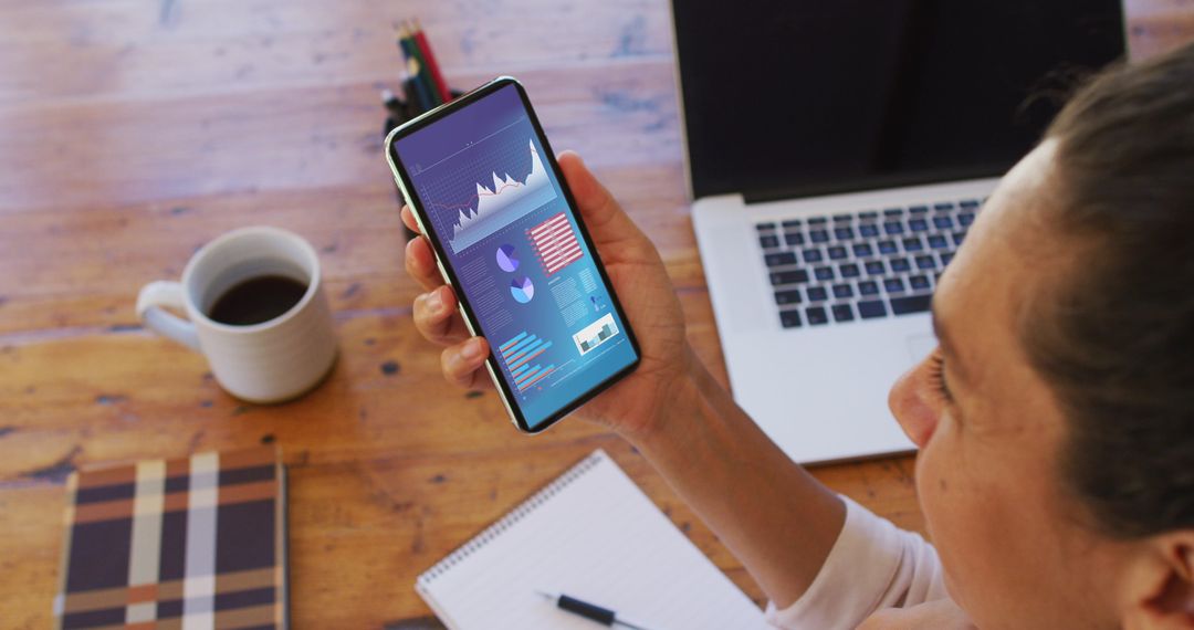 Professional Analyzing Statistics on Smartphone at Desk