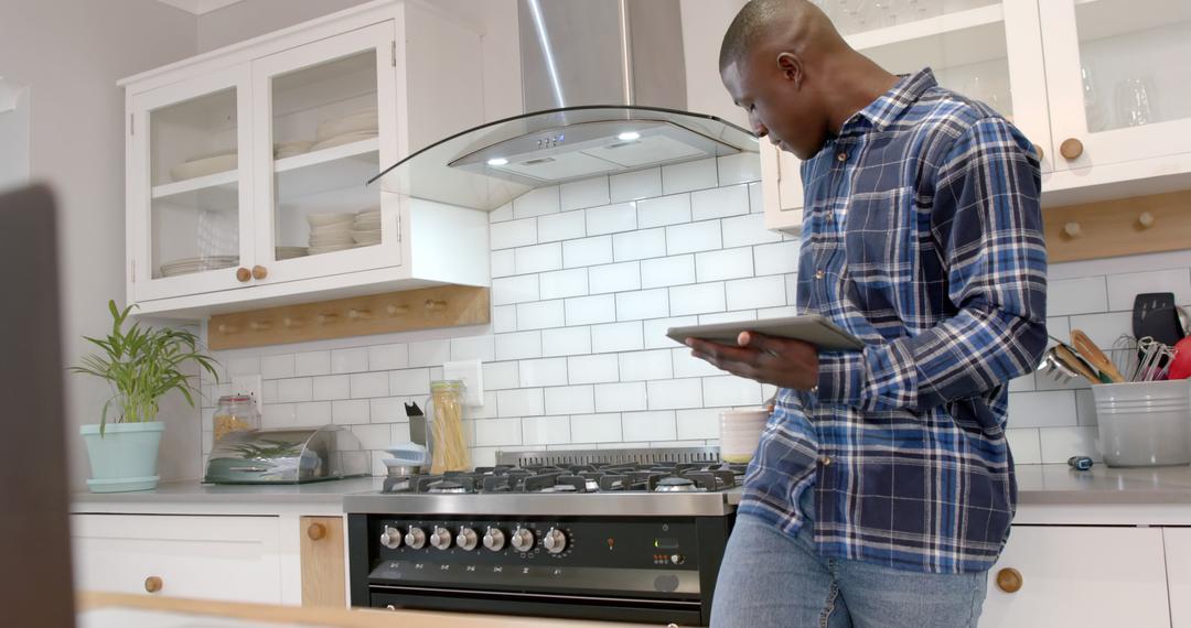 Man Drinking Coffee Using Tablet in Modern Kitchen at Home - Free Images, Stock Photos and Pictures on Pikwizard.com