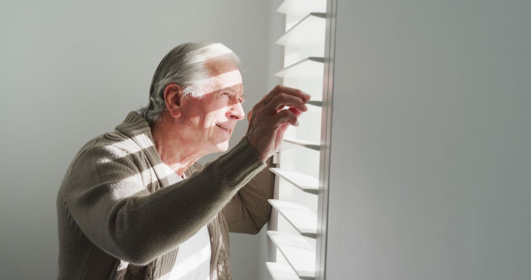 Elderly Man Gazing Out Window with Blinds - Free Images, Stock Photos and Pictures on Pikwizard.com