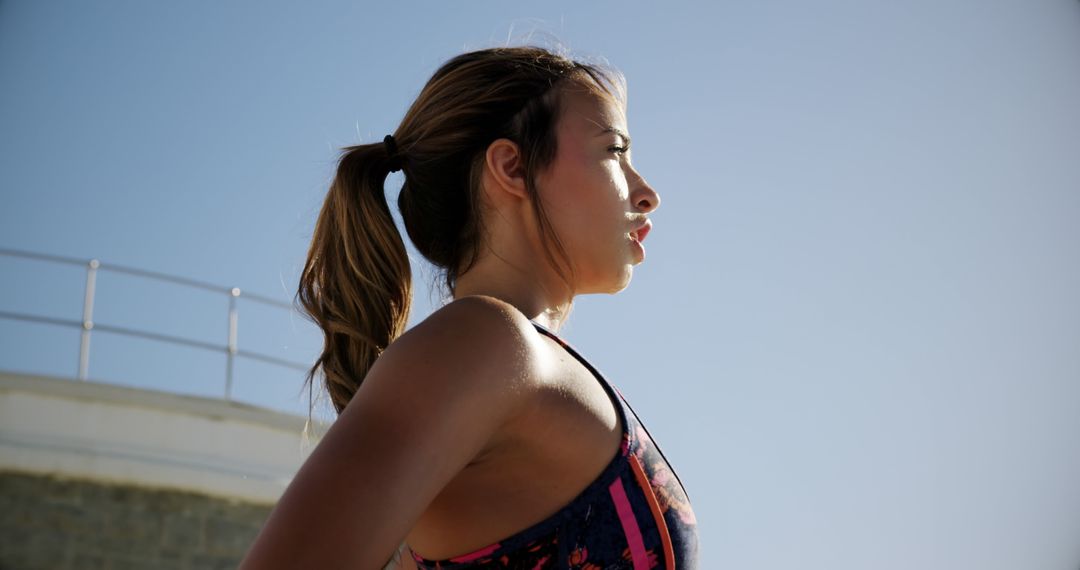 Fit woman exercising outdoors under clear sky - Free Images, Stock Photos and Pictures on Pikwizard.com