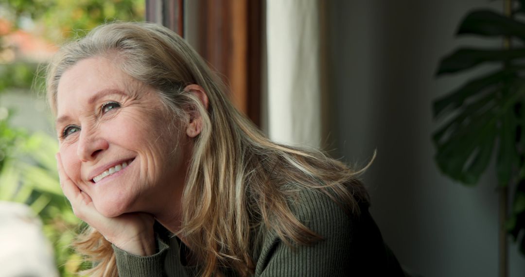 Senior Woman Relaxing by Window with Garden View