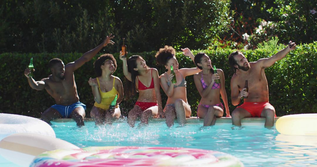 Backyard summer pool party friends splashing water, clinking bottles and taking selfie
