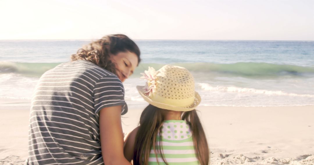 Mother and Daughter Sitting on Beach Shoreline - Free Images, Stock Photos and Pictures on Pikwizard.com