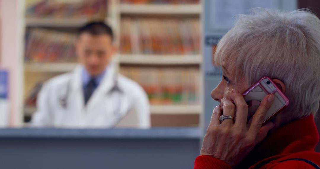 Senior Woman Talking on Phone at Clinic Reception Desk - Free Images, Stock Photos and Pictures on Pikwizard.com