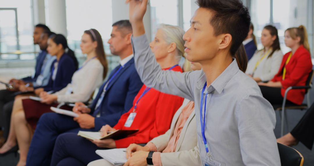 Businessman Raising Hand During Seminar to Ask Question