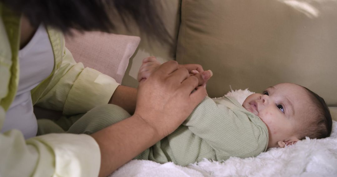 Mother Holding Baby Girl's Hands on Cozy Couch