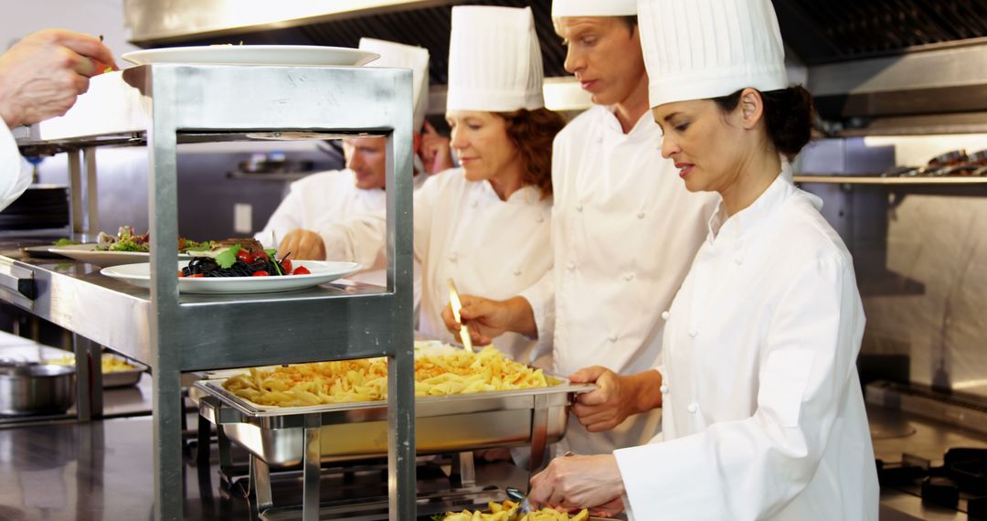 Chefs Preparing and Plating Pasta in Professional Kitchen - Free Images, Stock Photos and Pictures on Pikwizard.com