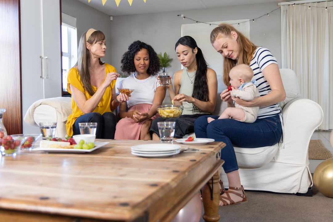 Diverse Women Gathering with Infant Sharing Snacks at Home