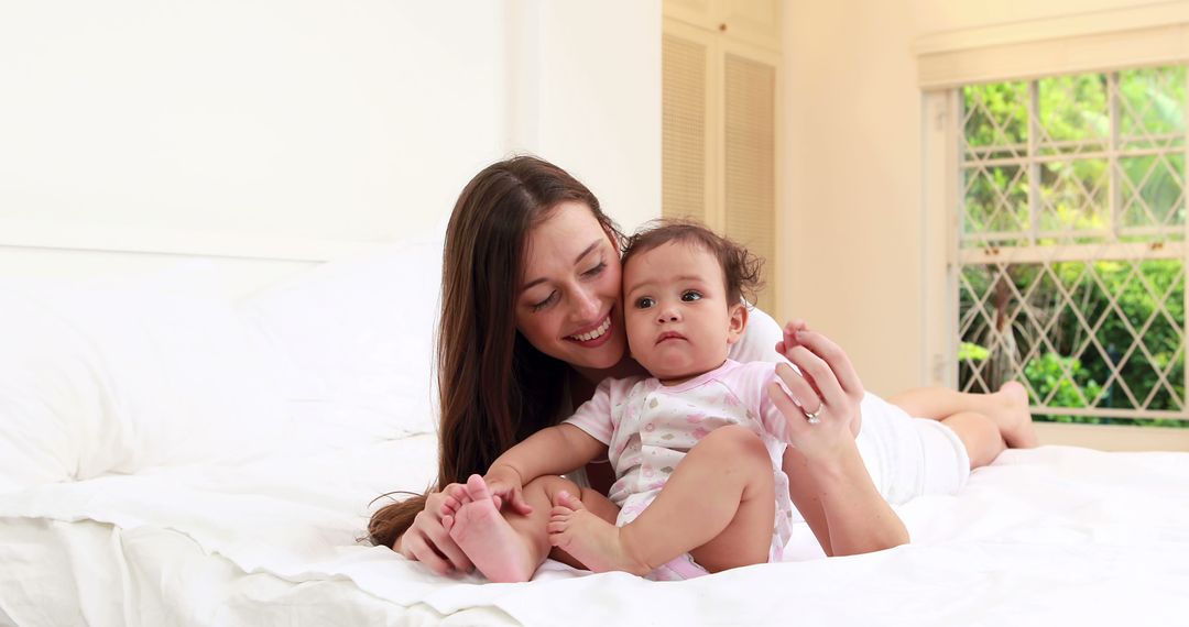 Woman Enjoying Quality Time with Baby in Bedroom - Free Images, Stock Photos and Pictures on Pikwizard.com