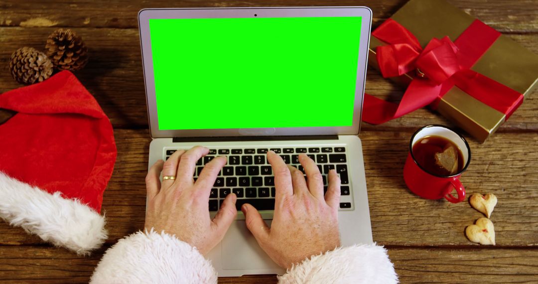 Santa Claus Typing on Laptop with Green Screen at Cozy Holiday Setting - Free Images, Stock Photos and Pictures on Pikwizard.com