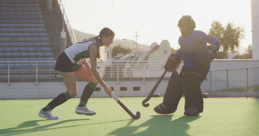 Female Field Hockey Players in Intense Match Shining Under Sun