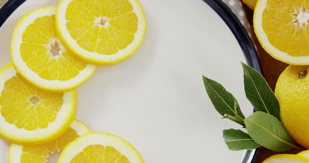 Fresh Lemon Slices on White Plate with Green Leaves Decoration - Free Images, Stock Photos and Pictures on Pikwizard.com