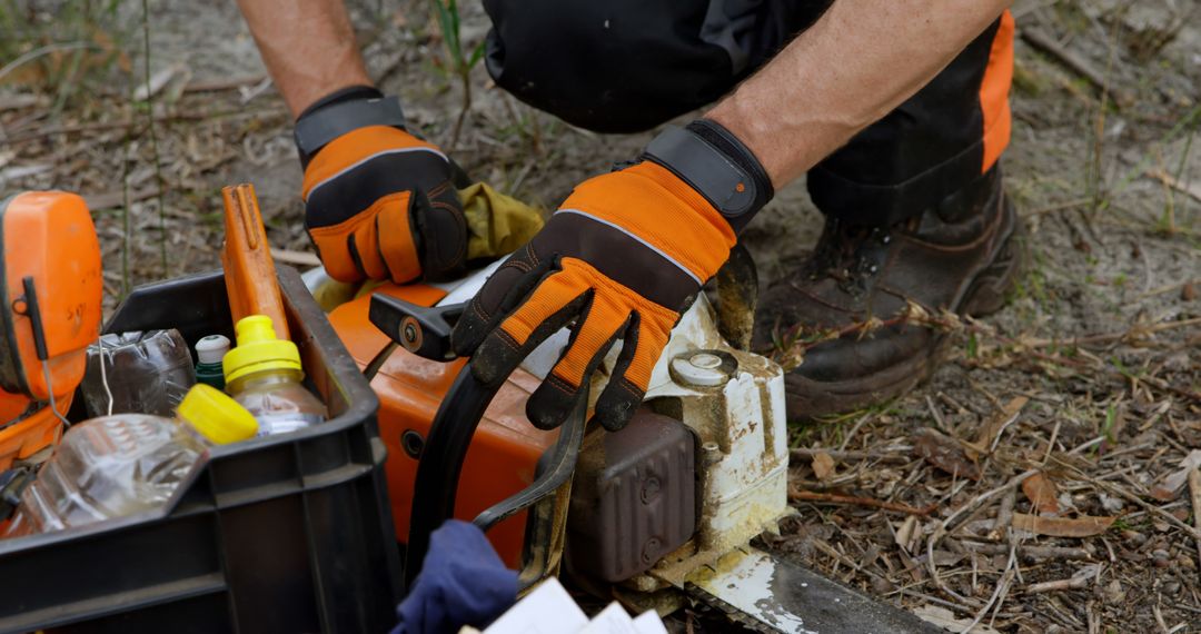 Worker Performing Maintenance on Chainsaw Outdoors - Free Images, Stock Photos and Pictures on Pikwizard.com