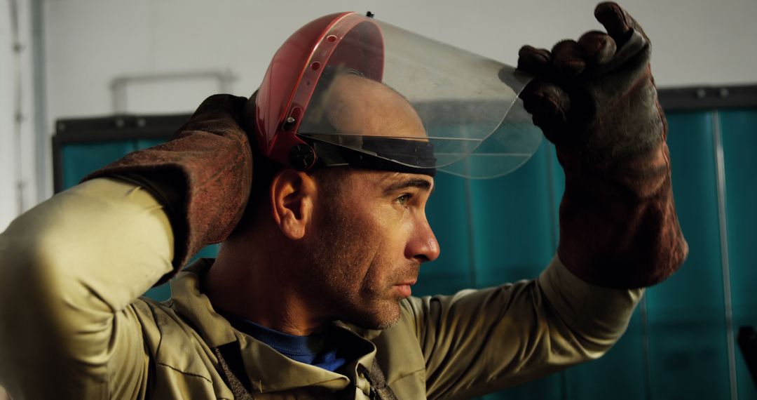 Industrial Worker Adjusting Protective Face Shield in Workshop - Free Images, Stock Photos and Pictures on Pikwizard.com