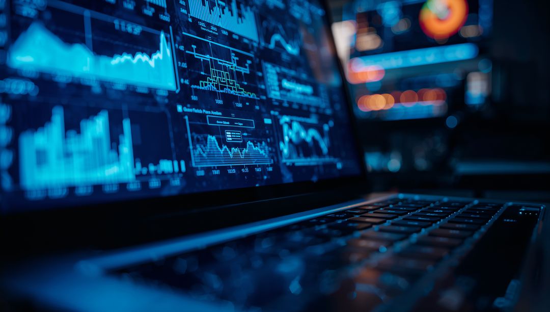 Analyzing Data Charts on Laptop in Dim Office