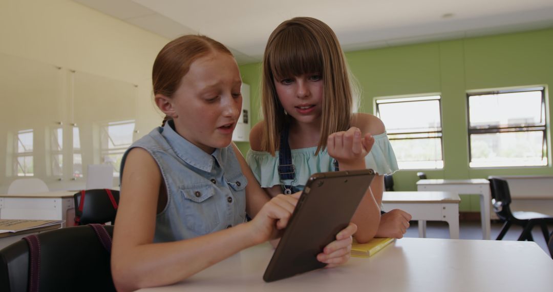 Two Young Girls Using Tablet in Classroom Setting - Free Images, Stock Photos and Pictures on Pikwizard.com