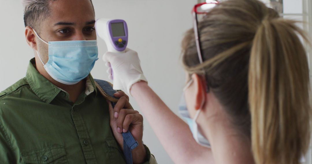 Health Worker Using Infrared Thermometer to Check Temperature - Free Images, Stock Photos and Pictures on Pikwizard.com