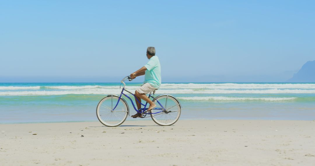 Senior Man Biking on Sunny Beach