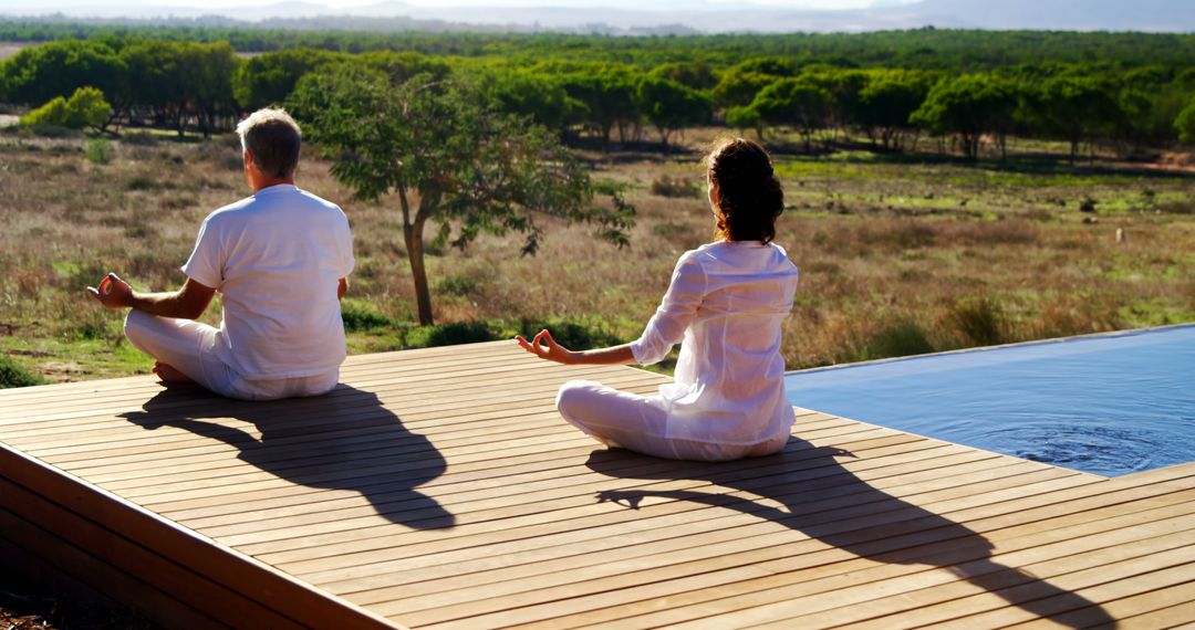 Senior Couple Meditating Outdoors on Wooden Deck by Pool - Free Images, Stock Photos and Pictures on Pikwizard.com