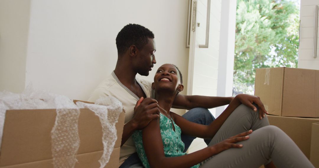 Happy Couple Smiling and Unpacking in New Home