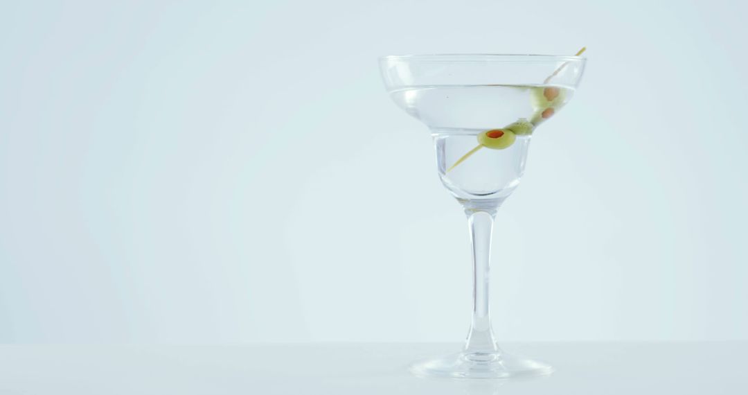 Martini cocktail glass with olives garnish on white background - Free Images, Stock Photos and Pictures on Pikwizard.com