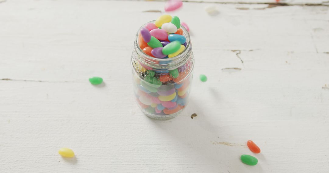Colorful Jelly Beans in Glass Jar on White Wooden Table - Free Images, Stock Photos and Pictures on Pikwizard.com