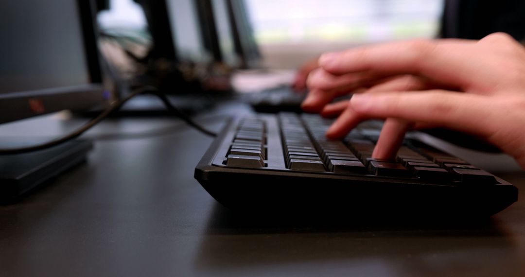 Hands Typing on Keyboard in Office Environment
