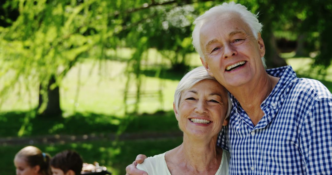 Happy Senior Couple Smiling in Sunlit Park - Free Images, Stock Photos and Pictures on Pikwizard.com