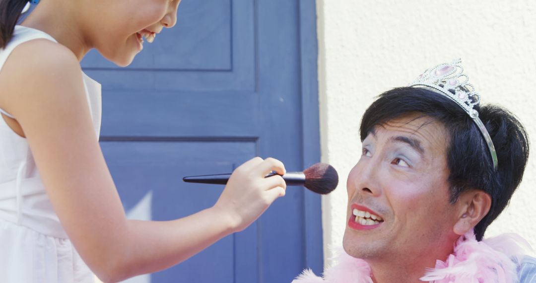 Girl Playfully Applying Makeup on Smiling Man in Tiara - Free Images, Stock Photos and Pictures on Pikwizard.com