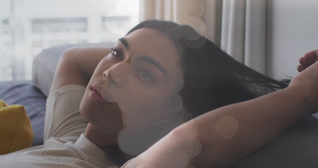 Serene Woman Relaxing on Couch with Dreamy Light Effects
