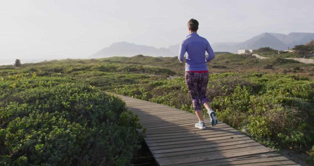 Senior Woman Jogging on Scenic Boardwalk at Dusk - Free Images, Stock Photos and Pictures on Pikwizard.com