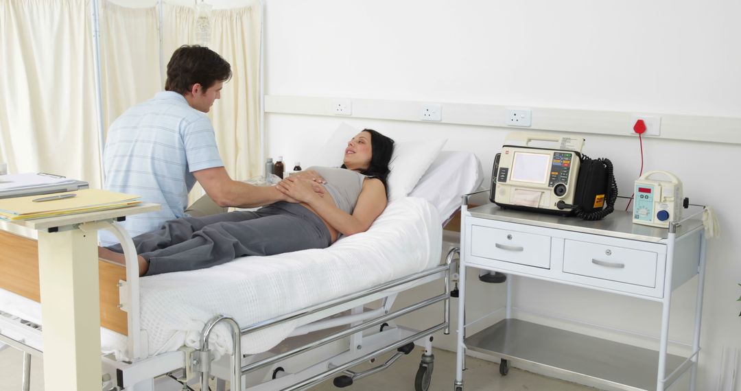 Man Comforting Pregnant Woman Lying on Hospital Bed - Free Images, Stock Photos and Pictures on Pikwizard.com