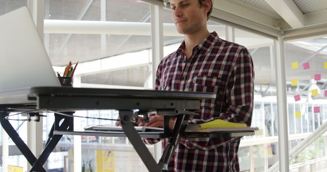 Young Professional Using Standing Desk in Modern Office - Free Images, Stock Photos and Pictures on Pikwizard.com