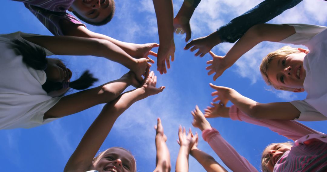 Diverse Group of Kids Join Hands Under Blue Sky - Free Images, Stock Photos and Pictures on Pikwizard.com