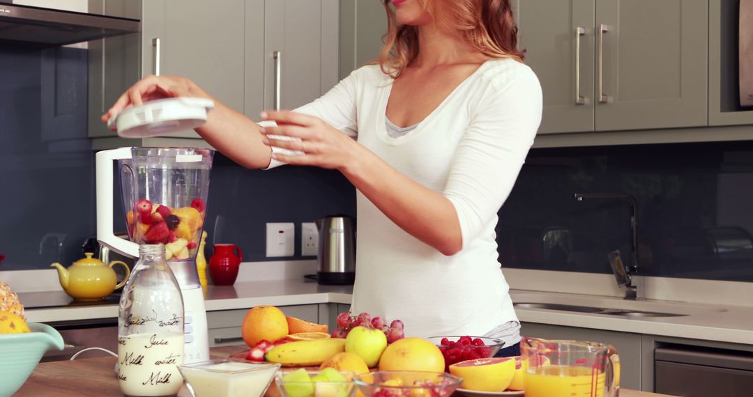 Woman Making Healthy Fruit Smoothie in Modern Kitchen - Free Images, Stock Photos and Pictures on Pikwizard.com