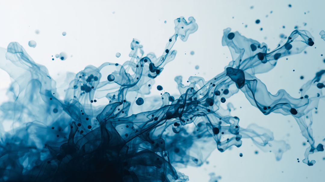 Deep Blue Ink Swirling in Water Creating Fluid Ribbons and Droplets