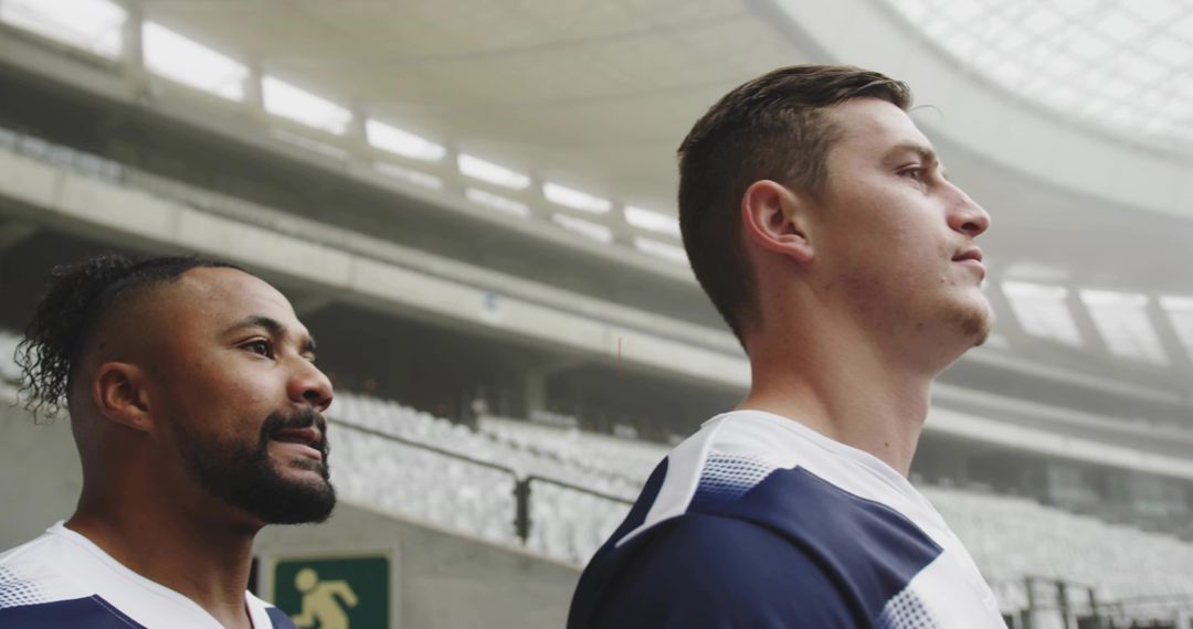 Two teammates warming up on stadium concourse preparing for game with focused determination