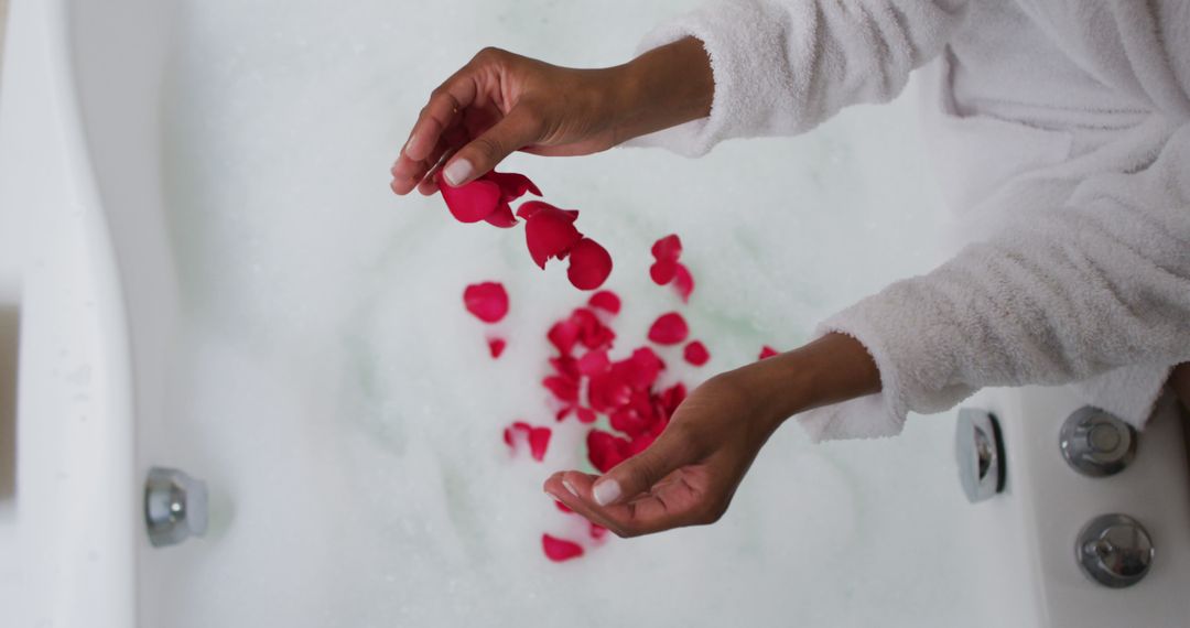 Person Adding Rose Petals to Relaxing Bubble Bath - Free Images, Stock Photos and Pictures on Pikwizard.com