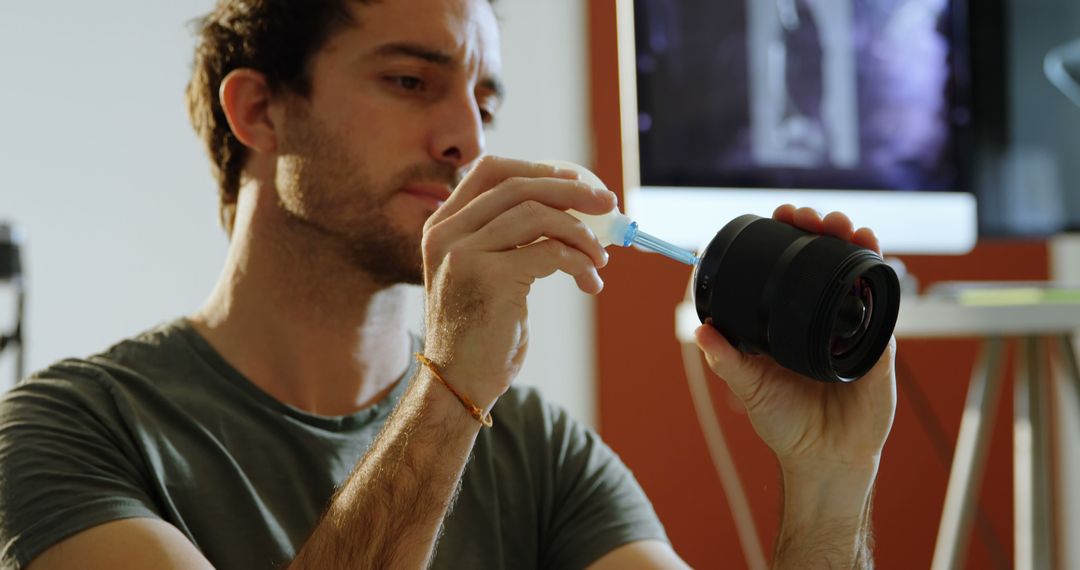 Man Cleaning Camera Lens with Clean Air Blower in Home Studio - Free Images, Stock Photos and Pictures on Pikwizard.com