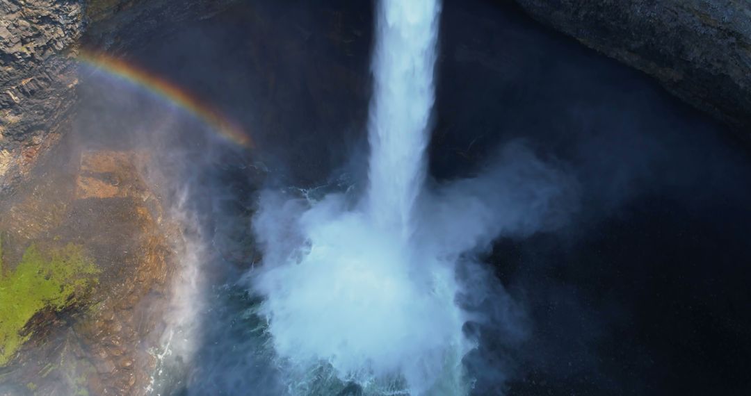 A waterfall's aerial shot captures its majestic force and a misty rainbow's delicate beauty. - Free Images, Stock Photos and Pictures on Pikwizard.com