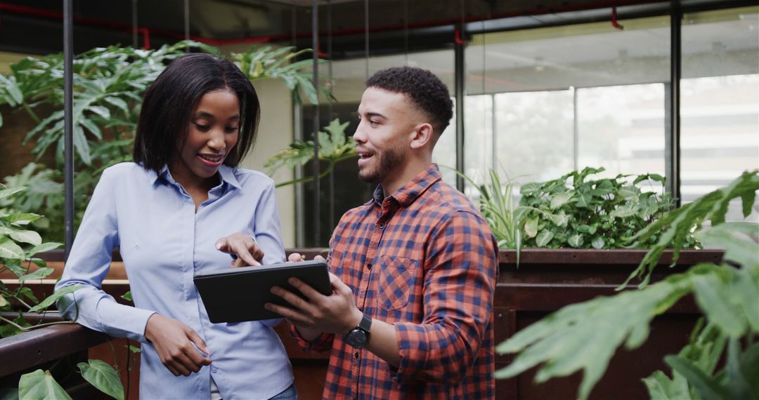 Diverse Colleagues Collaborating on Tablet in Modern Office