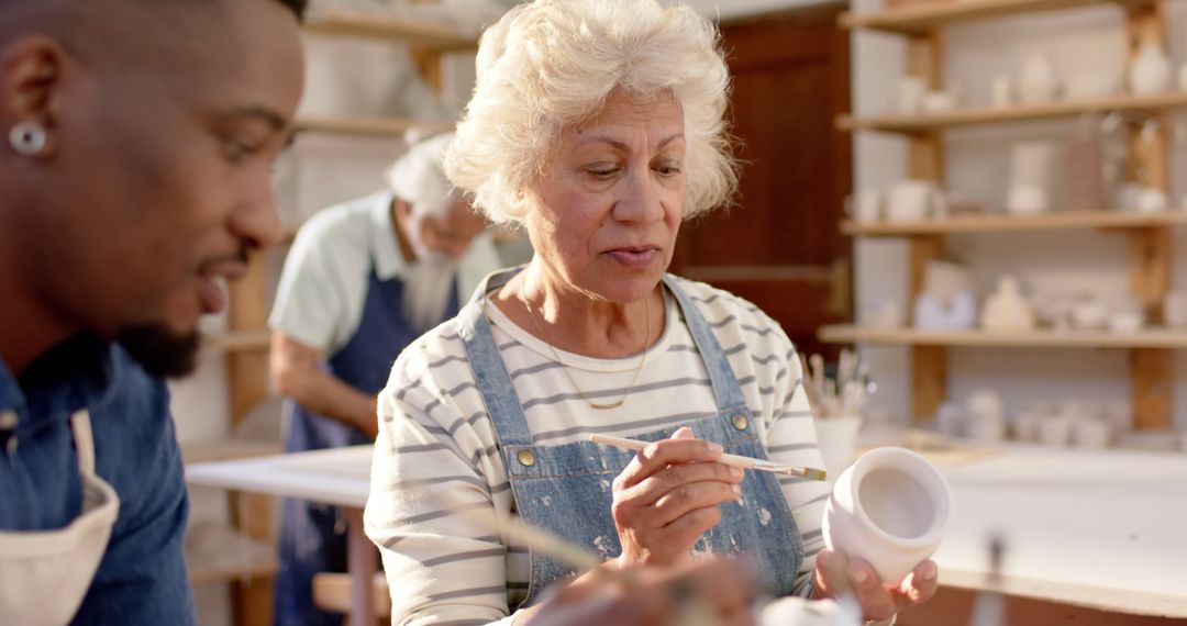 Elderly woman and man painting pottery in ceramics class - Free Images, Stock Photos and Pictures on Pikwizard.com