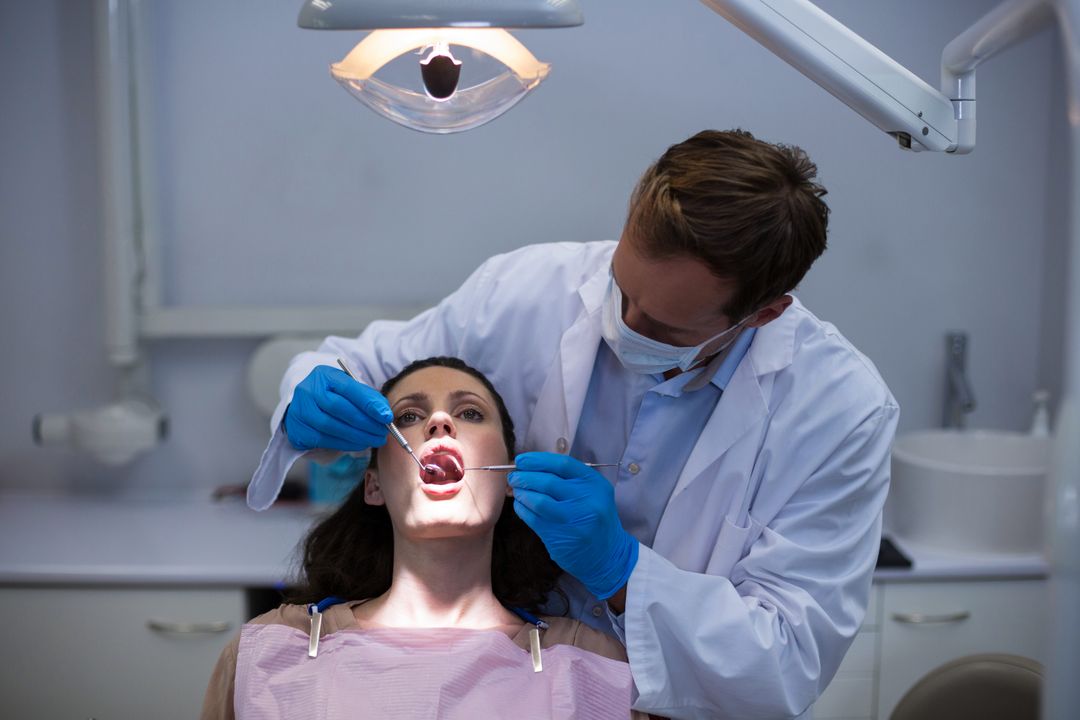 Dentist Examining Female Patient at Dental Clinic - Free Images, Stock Photos and Pictures on Pikwizard.com